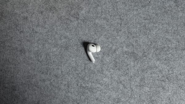 A photo of my left AirPod, lying on a grey felt desk mat
